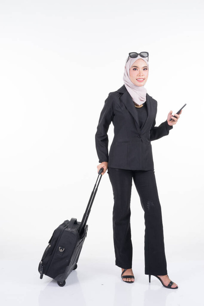 Muslim businesswoman on a business trip, with luggage isolated on white background. Suitable for cut out, manipulation or composite works for travel or business concept. Full length portrait. - Photo, image