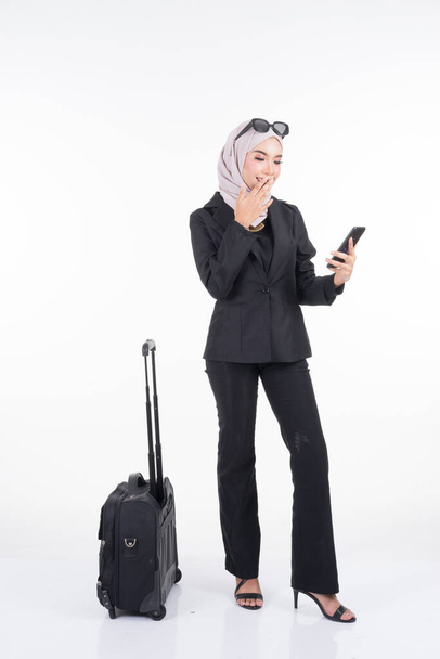 Moslim zakenvrouw op zakenreis, met bagage geïsoleerd op witte achtergrond. Geschikt voor knippen, manipuleren of composietwerken voor reizen of zakelijk concept. Volledig portret. - Foto, afbeelding