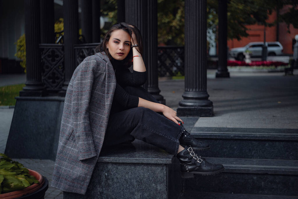 Όμορφη νεαρή μελαχρινή γυναίκα περπατάει στη Μόσχα. Εξωτερικό πορτρέτο μόδας της εκπληκτικής μοντέρνα γυναίκα ποζάρουν στο δρόμο. - Φωτογραφία, εικόνα
