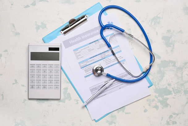 Krankenversicherungsformular mit Stethoskop und Taschenrechner auf hellem Hintergrund - Foto, Bild