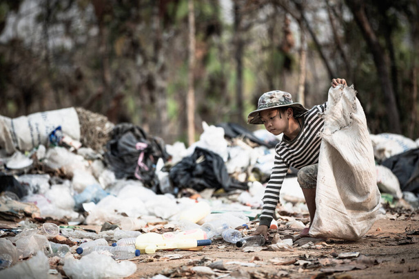 Τα φτωχά παιδιά συλλέγουν σκουπίδια προς πώληση λόγω φτώχειας, ανακύκλωσης σκουπιδιών, παιδικής εργασίας, έννοιας της φτώχειας, Παγκόσμια Ημέρα Περιβάλλοντος, - Φωτογραφία, εικόνα