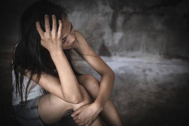 depressive Frau, die in der Ecke des Zimmers sitzt und Angst vor Gewalt durch Belästigung, häusliche Gewalt und Vergewaltigung empfindet, geschlagen und vergewaltigt in der Ecke sitzend, Kopierraum. - Foto, Bild