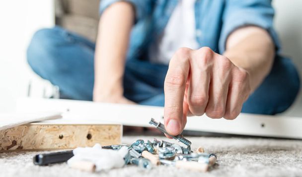 Hand grabbing screw. Man assembling new furniture for home concept - Fotoğraf, Görsel