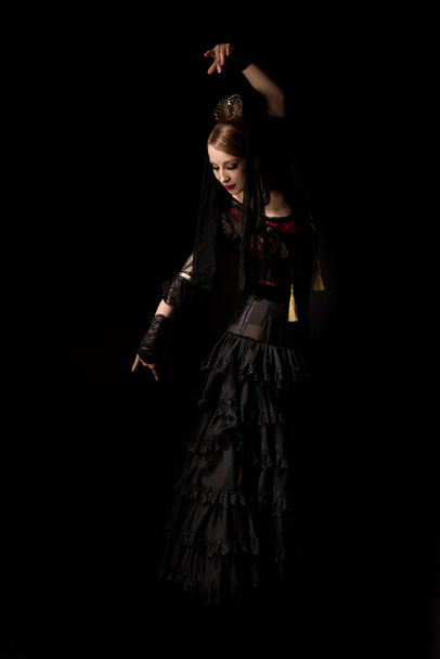 pretty dancer in dress gesturing while dancing flamenco isolated on black  - Foto, Imagem