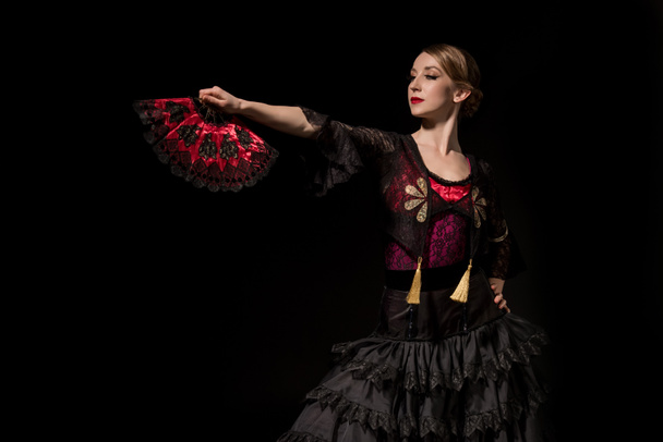 elegant woman holding fan and dancing flamenco isolated on black  - Foto, afbeelding