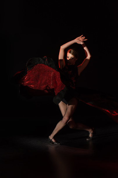 pretty young dancer with hands above head dancing flamenco on black  - Fotoğraf, Görsel