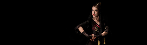 concepto panorámico de bonita joven bailarina de flamenco de pie aislada sobre negro
  - Foto, imagen