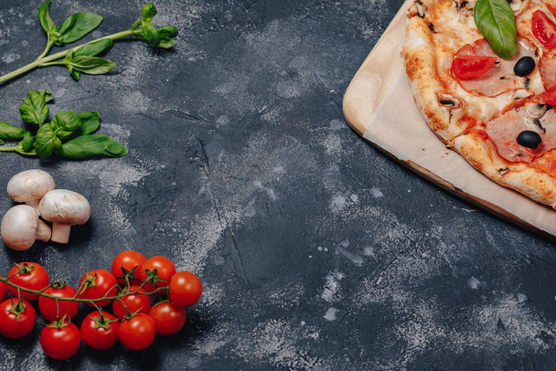 delicious Neapolitan pizza on a blackboard with cherry tomatoes, free space for text - Valokuva, kuva