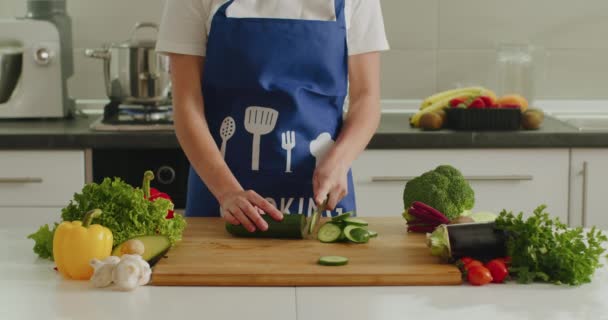 Una mujer está cortando pepino en el tablero de la cocina. Preparación de ensaladas. 4k
 - Imágenes, Vídeo