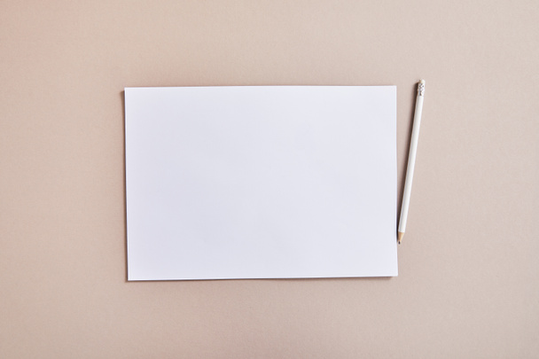 vista superior do papel branco em branco com lápis na superfície bege
 - Foto, Imagem