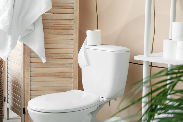 Toilet bowl and rolls of paper in restroom - Fotó, kép