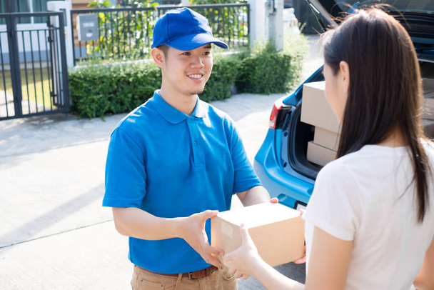 Delivery service male in uniform give cardboard box package to receiver customer client front home, fast express offsite when crisis coronavirus, covid19 new normal lifestyle concept. - Photo, Image