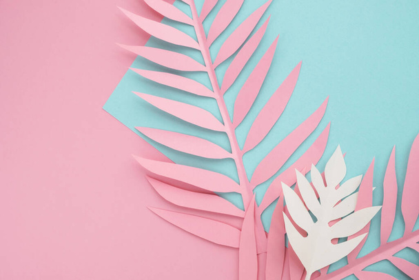 Tropical paper leaves on pastel background. Minimal bright summer composition. Top view, flat lay, copy space - Foto, immagini