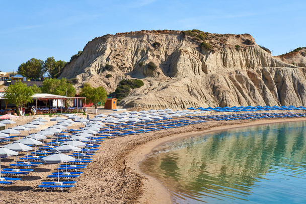 Leżaki z parasolami na plaży ze skałami w miejscowości Kolymbia. Wyspa Rodos. Grecja - Zdjęcie, obraz
