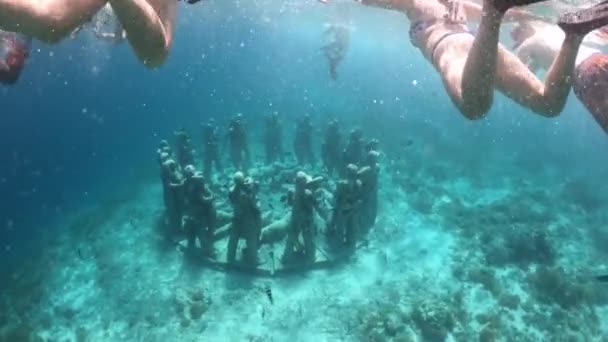Turistas haciendo snorkel y buceo libre en círculo de 48 figuras de tamaño natural que esperaban convertirse lentamente en un arrecife de coral frente a la costa de la isla Gili Meno entre Bali y Lombok
. - Metraje, vídeo