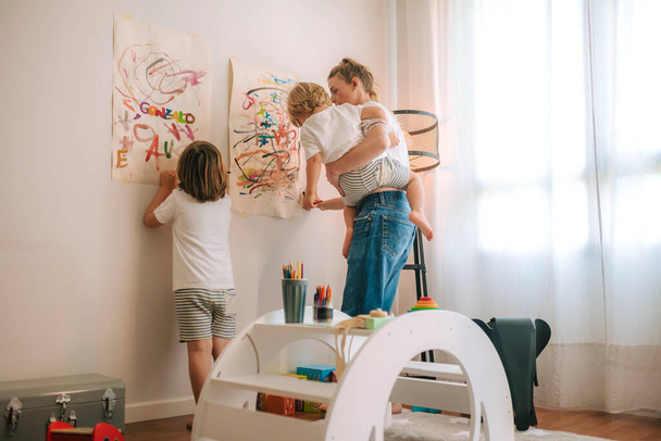 mladá matka a její dvě děti malují doma. zábava během karantény. Rodina doma. coronavirus. - Fotografie, Obrázek