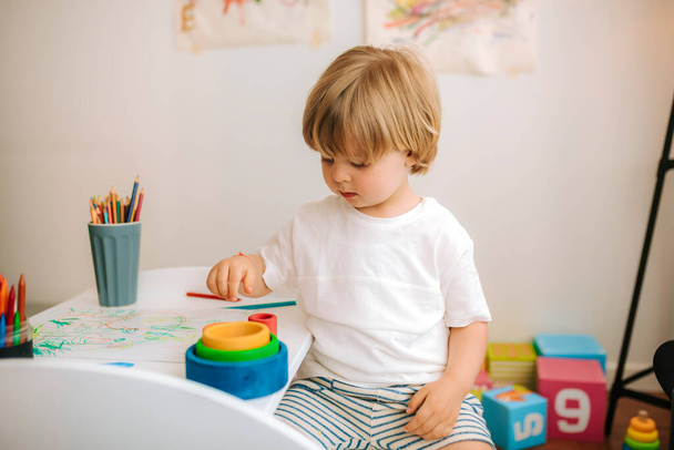Malý blonďatý chlapec si doma hraje na malíře. zábava během karantény. rodina doma koronavirus. - Fotografie, Obrázek