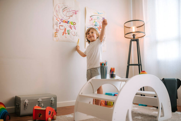 Der kleine blonde Junge spielt zu Hause Malerei. Unterhaltung während der Quarantäne. Familie zu Hause Coronavirus. - Foto, Bild