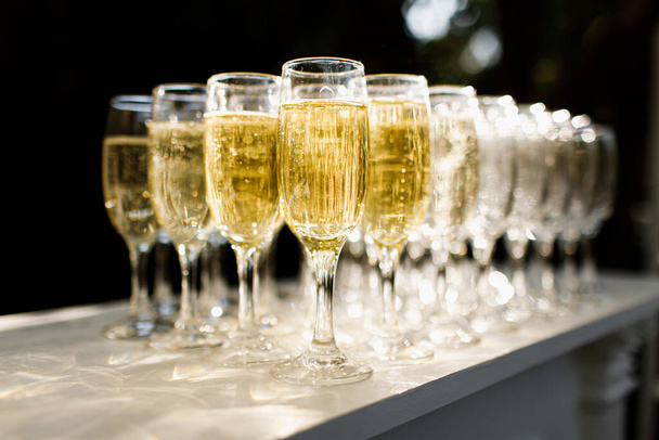 Gläser gefüllt mit Champagner. Weiche Fokussierung auf die Frontscheibe. - Foto, Bild