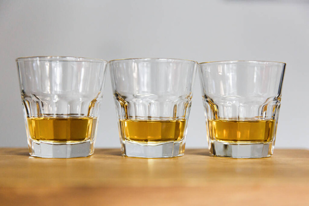Three glasses of whiskey filled by alcohol. Standing on the table. - Valokuva, kuva