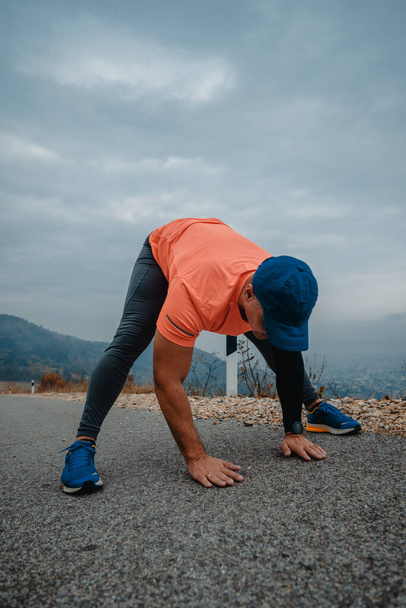 Подходящий мужчина средних лет в спортивной одежде готовится к бегу - Фото, изображение