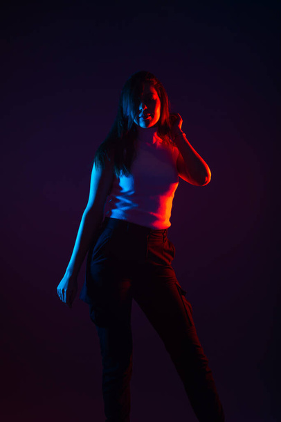 Blue and red light portrait of a female model on a black background with high contrast - 写真・画像