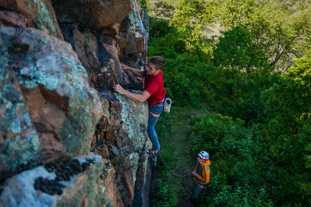 Zwei Männer wollen klettern und das Kletterseil am Gurtzeug befestigen - Foto, Bild