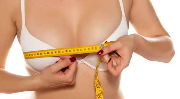 woman measures her breasts with a measuring tape - Photo, Image