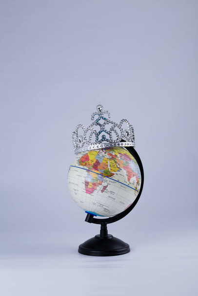 пластиковый глобус с короной на синем фоне
  - Фото, изображение
