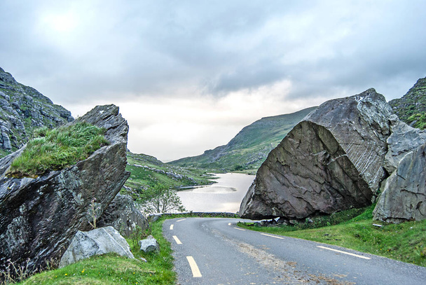 Дорога через ландшафт с озером на заднем плане, Ирландия - Фото, изображение