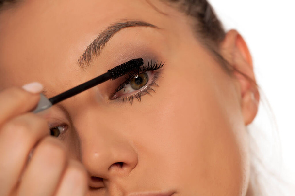 Closeup of young woman applying mascara - Photo, Image