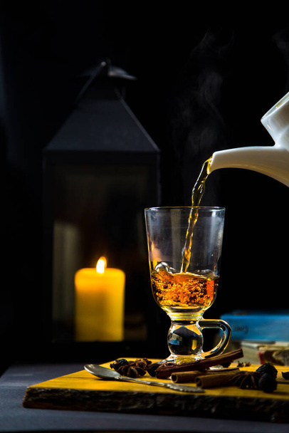 Наливание черного горячего свежего чая из стеклянного чайника за завтраком, утреннее кафе
 - Фото, изображение