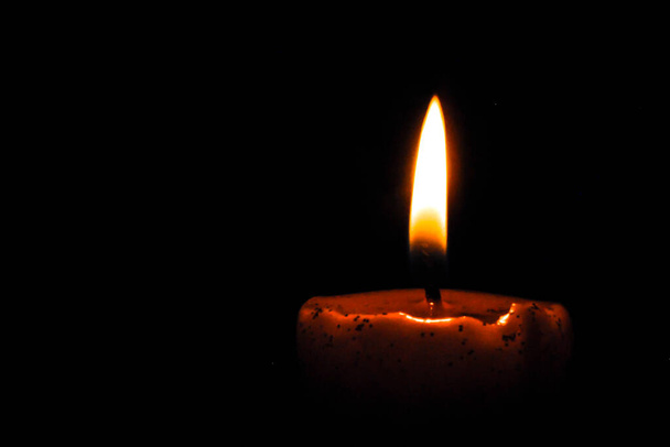 Jedna świeca jasno płonąca w czarnym tle - Zdjęcie, obraz