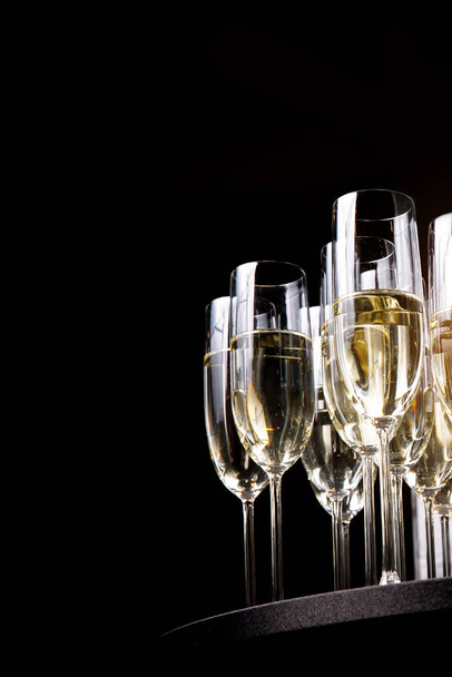 Uma fila de copos de champanhe no fundo preto. Representa a festa. Espaço livre para o seu texto e pode ser usado como modelo para web design e revista
 - Foto, Imagem