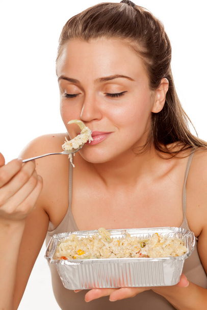 una joven mujer feliz huele comida para tomar sobre fondo blanco
 - Foto, Imagen