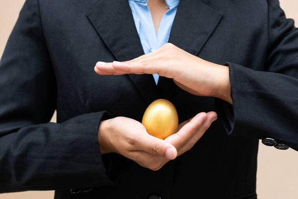 Рука ділової жінки тримає золоте яйце, щоб займатися бізнесом, можливість може прийти тільки один раз.
. - Фото, зображення