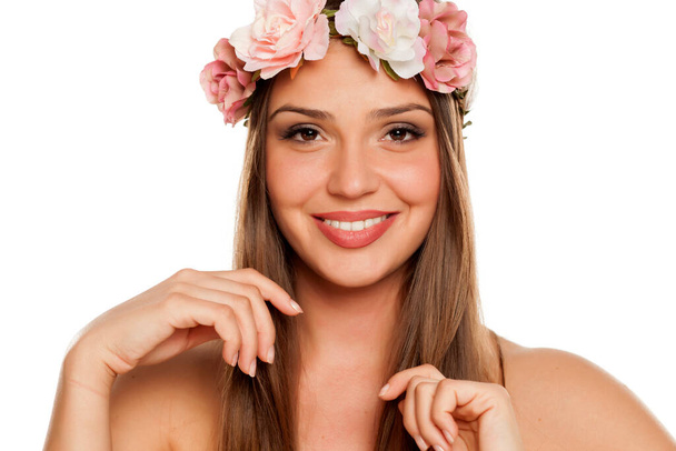 a happy young happy woman with a wreath of flowers on her head on white background - Photo, Image