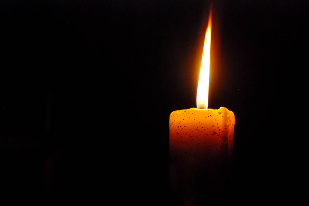 Yksi kynttilä palaa kirkkaasti mustalla taustalla - Valokuva, kuva