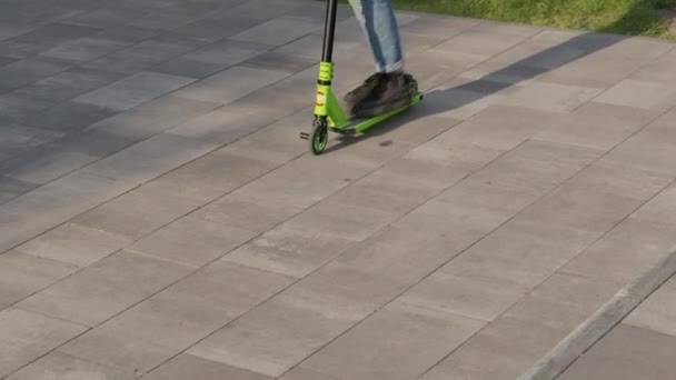 Tiener paardrijden scooter glijden op de stoep. - Video