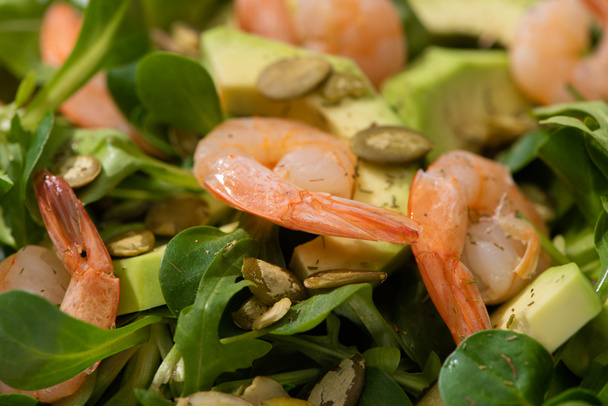 close up view of fresh green salad with pumpkin seeds, shrimps and avocado - Fotoğraf, Görsel