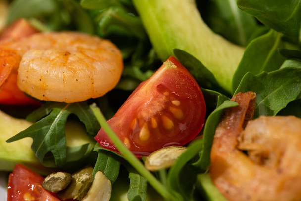vista de perto da salada verde fresca com sementes de abóbora, tomates cereja, camarões e abacate
 - Foto, Imagem
