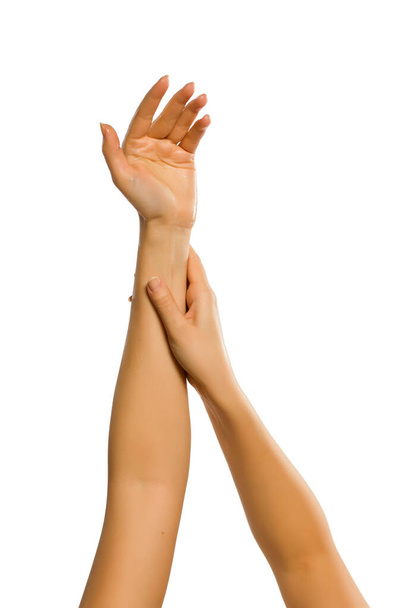 primer plano de las manos femeninas aplicando crema de manos sobre fondo blanco
 - Foto, imagen