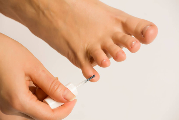 mujer aplicando un esmalte de uñas en los dedos de los pies
 - Foto, Imagen