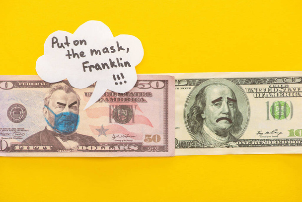 felső nézet a bankjegyek rajzolt orvosi maszk és arckifejezések közelében beszéd buborék sárga háttér - Fotó, kép