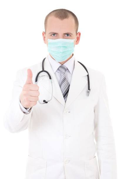 Portrait of young doctor in mask thumbs up isolated on white - Fotó, kép