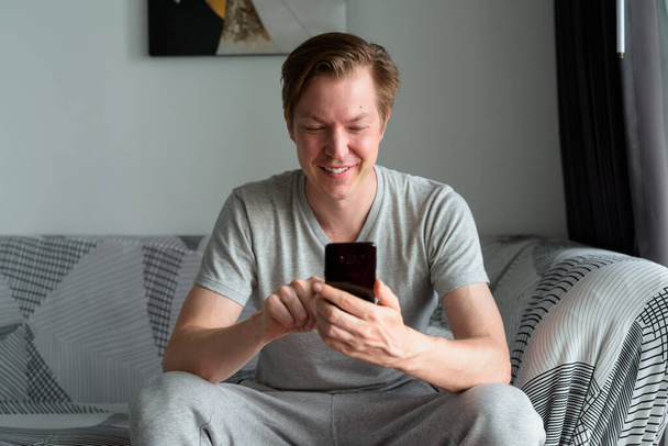 Portrait of young handsome Scandinavian man relaxing in the living room and staying at home - Фото, зображення