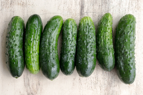 Fresh cucumbers from garden beds on a wooden surface - Valokuva, kuva