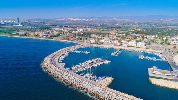 Légi madártávlatból kilátás Zygi halászati falu kikötő, Larnaca, Ciprus. A kikötőben horgonyzó halászhajók dokkolt jachtjaikkal és Limassol melletti városképükkel felülről. - Fotó, kép