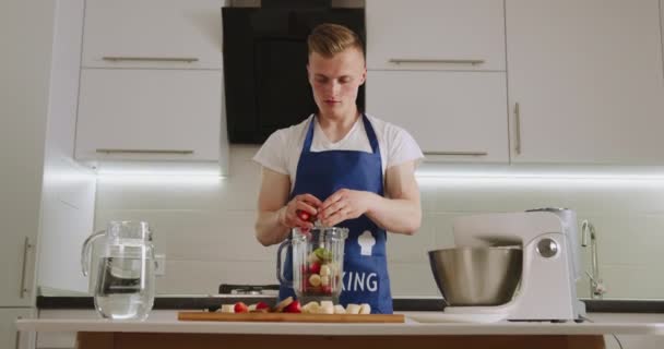 A man is filling a blender bowl with fruit. Making smoothies. 4K - Footage, Video