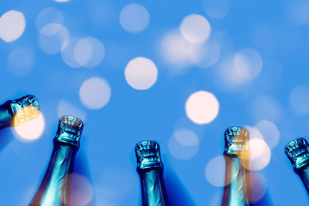 Champagne bottles on a blue background with bokeh lights - Photo, Image